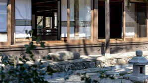Ein traditionelles japanisches Gebäude mit Holzarchitektur, großen Schiebetüren und einem Steinglaternen.