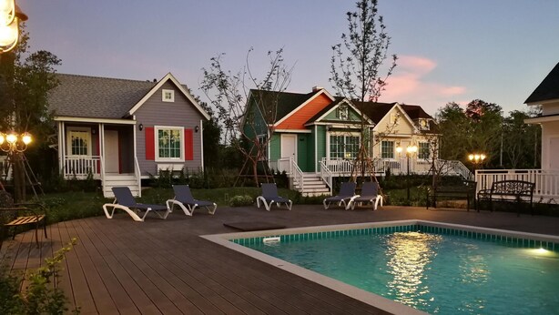 A wooden deck with lounge chairs and a swimming pool. - Vermont Khao Yai (Pak Chong)