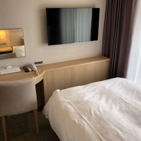A hotel room with a bed, a desk with a telephone, a flat-screen TV mounted on the wall, and a window with curtains. - Nonsmoking Room entrustment / Tamanagun Kumamoto (Tamanagun)