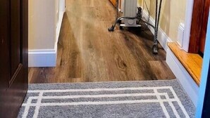 A hallway with wooden flooring, a gray rug, a metal cart, and a door leading to another room. - Adorable 1 bedroom mins away to NYC in Teaneck

 (Teaneck)