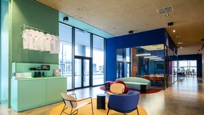 A modern office space with a reception area, seating area, and large windows. - CX Venice Mestre (Mestre)