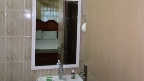 A bathroom with a white sink, a mirror, and a toilet. - Annex House For Rent (Serrekunda)