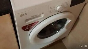 A front-loading LG washing machine in a kitchen with beige tiled walls. - Annex House For Rent (Serrekunda)
