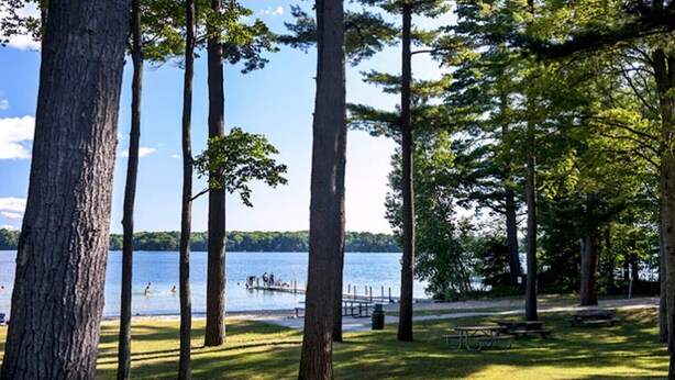 A lakeside park with picnic tables and a dock. - Modern Bungalow - Endless Recreation, Close to TV (Traverse City)