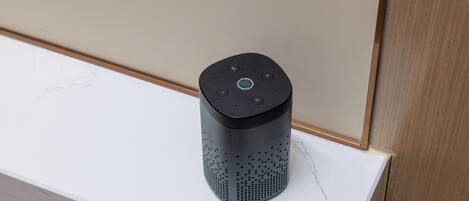 A smart speaker on a white marble countertop.