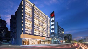A modern hotel with a prominent sign, large windows, and a well-lit facade. - Ya Chen Hotel (Guangzhou)