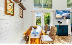 A dining area with a wooden table, chairs, and a view of the outdoors.