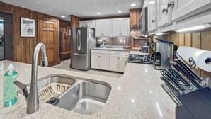 A kitchen with a stainless steel sink, white cabinets, a built-in oven, and a gas stove.