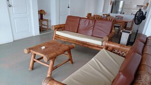 A room with a wooden sofa, a matching wooden table, and a small wooden stool. - Casa de Playa Cahuve Frente al mar (Cardalito)