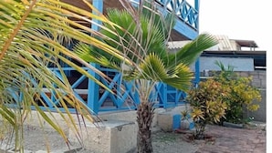 A blue building with a staircase and a palm tree in the foreground. - Casa de Playa Cahuve Frente al mar (Cardalito)