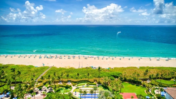 A beach resort with a large sandy beach, clear turquoise waters, and lush greenery. - Isla Palma Singer Island (Singer Island)