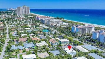 Vista aérea de una zona residencial costera con playa, que incluye edificios de varios pisos y un lugar señalado.