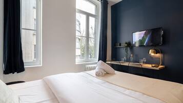 Escritorio, tabla de planchar con plancha, internet y ropa de cama