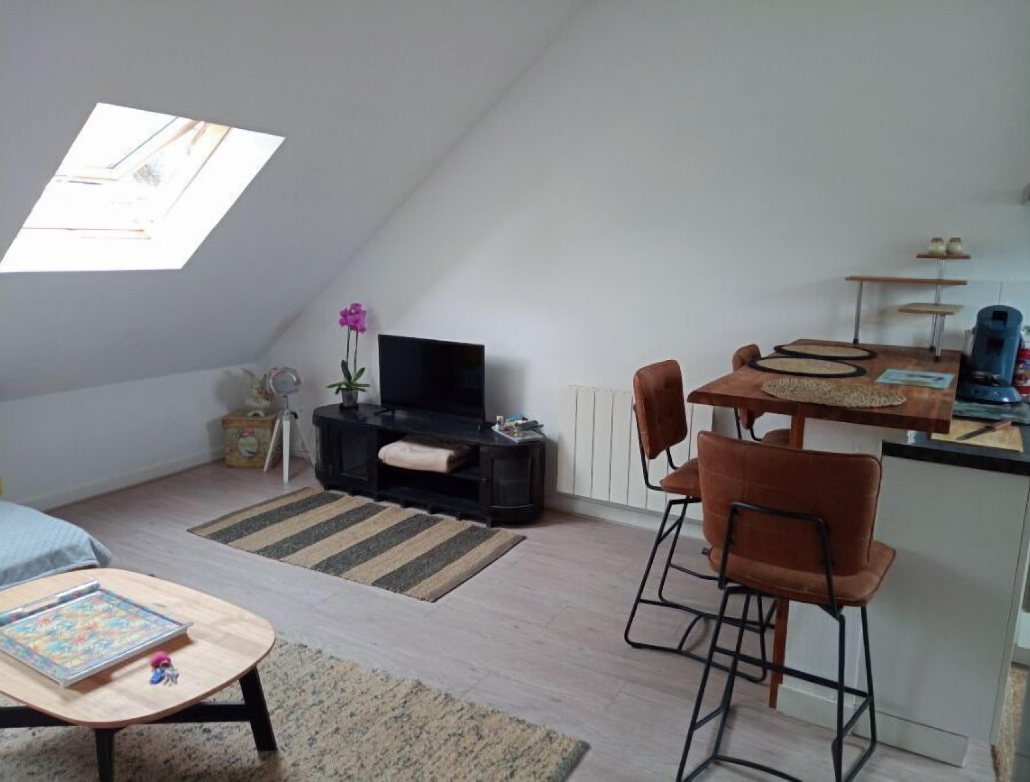 Un loft moderno con comedor, zona de estar y televisión.