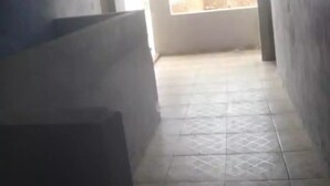Un couloir doté d’un sol carrelé, une porte donnant sur l’extérieur et une fenêtre offrant une vue sur l’extérieur.