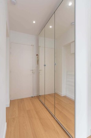 Stylish hallway with a mirrored closet door and recessed lighting.