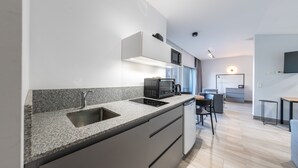 Eine moderne Küche mit Granit-Arbeitsplatten, einer eingebauten Mikrowelle und einem Geschirrspüler.