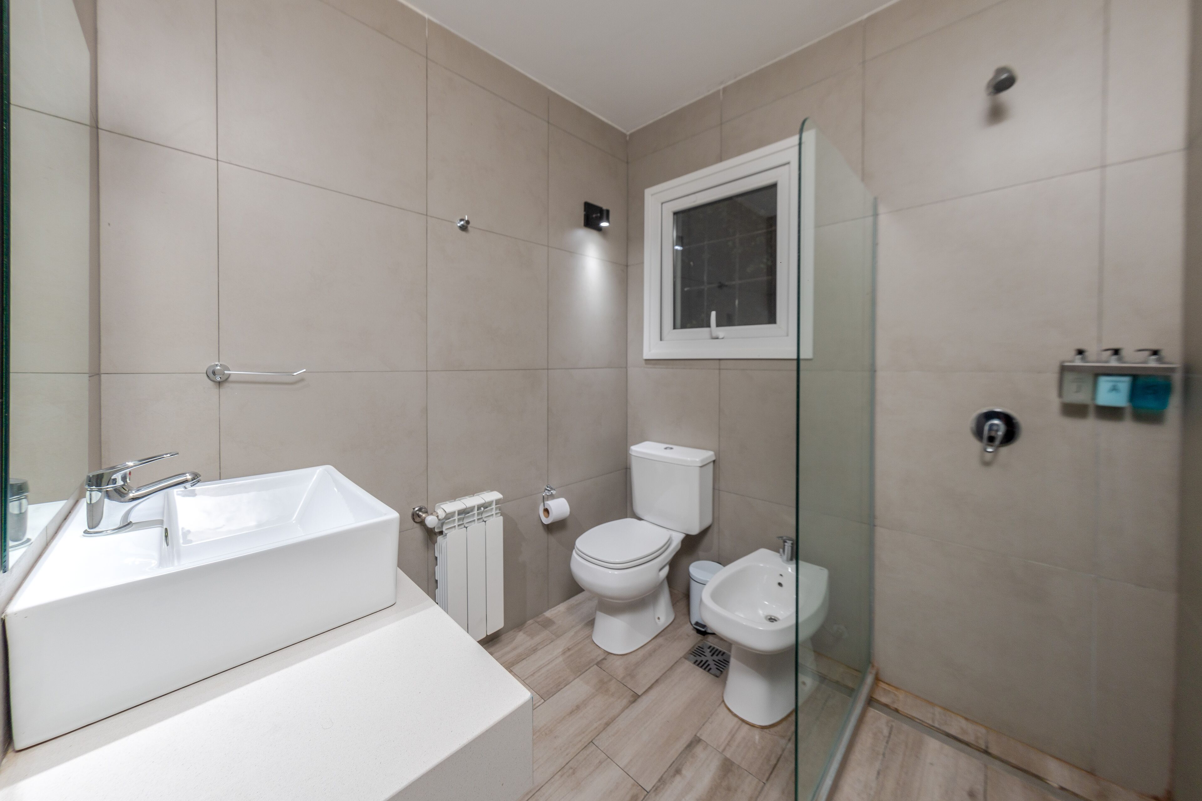 Un baño moderno con una bañera blanca grande, un inodoro y un bidé.