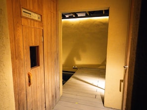 A narrow wooden hallway with a small window and a door.