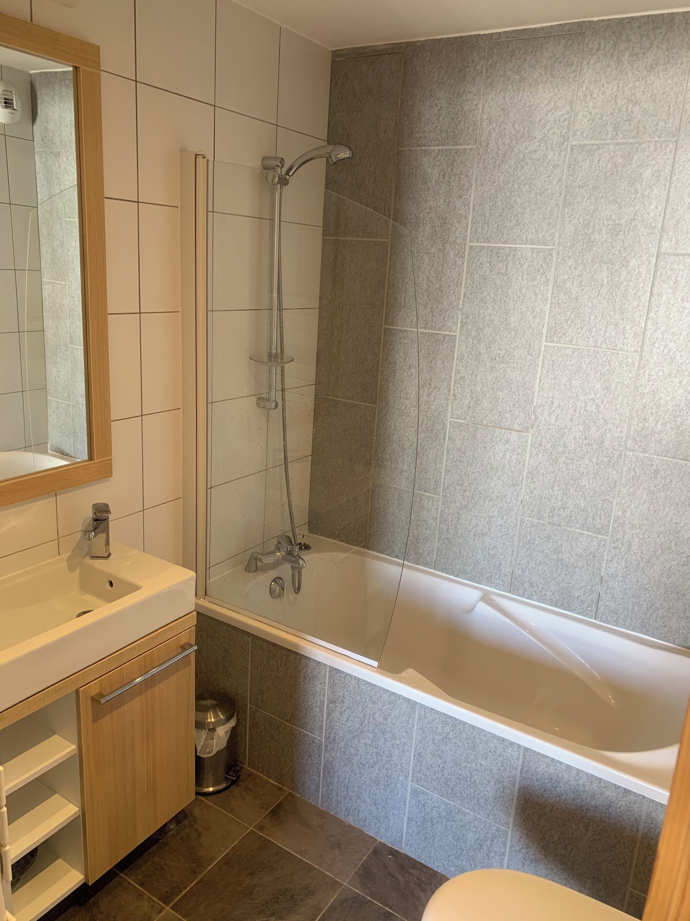 A modern bathroom with a bathtub, a shower, and a sink.