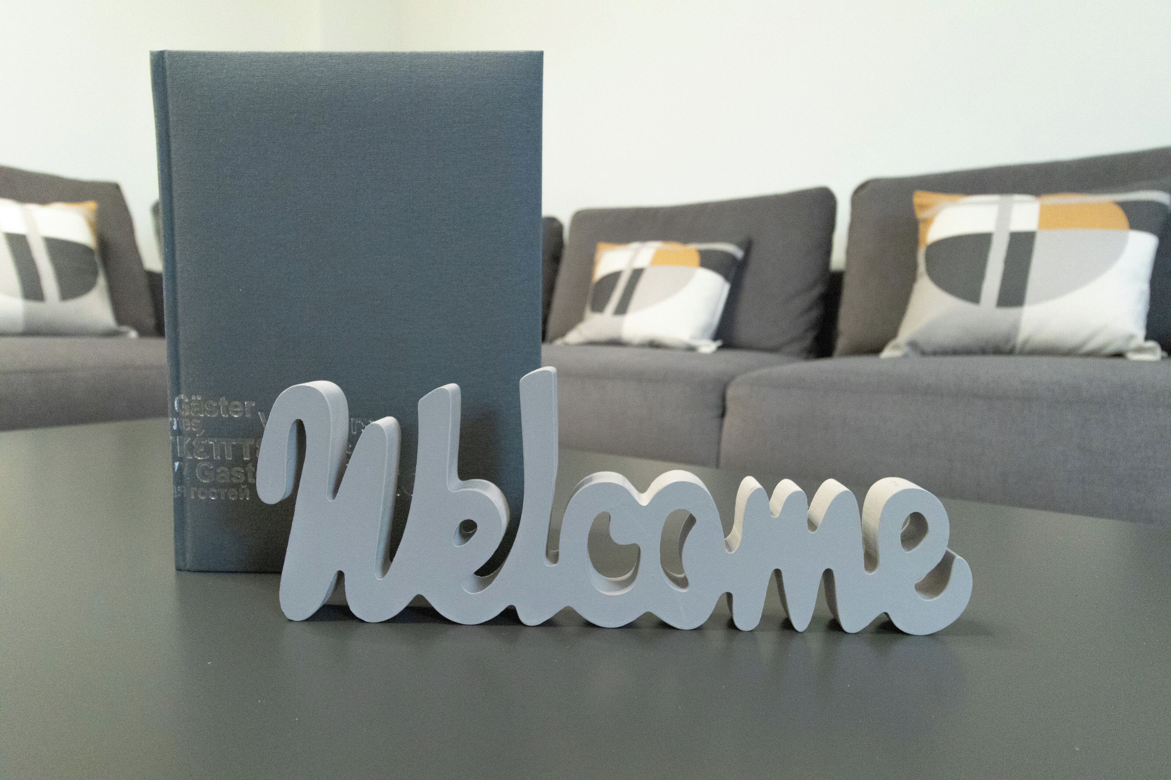 A dark blue book titled "Käthe Kastner" on a table with a "Welcome" sign.