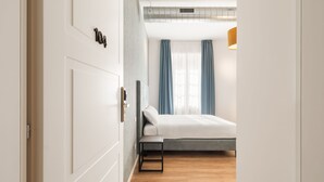 A modern hotel room with a bed, a bedside table, and a window with curtains. - Adelante Rooms (Rome)