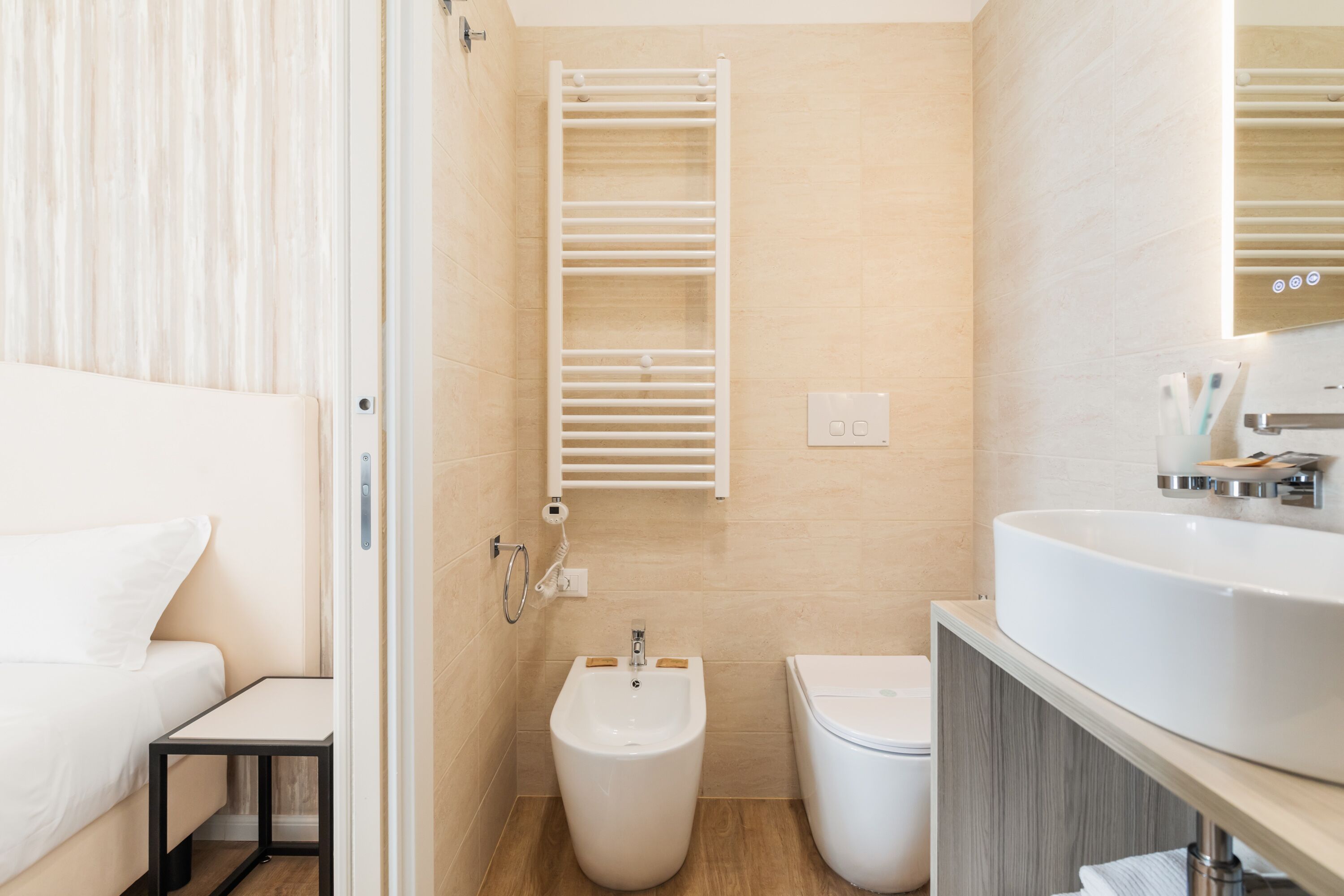 Een moderne badkamer met een hygiëneschuiver, toilet en wastafel.
