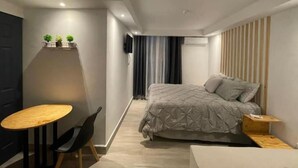 Un dormitorio moderno con una cama, una mesita y una silla.
