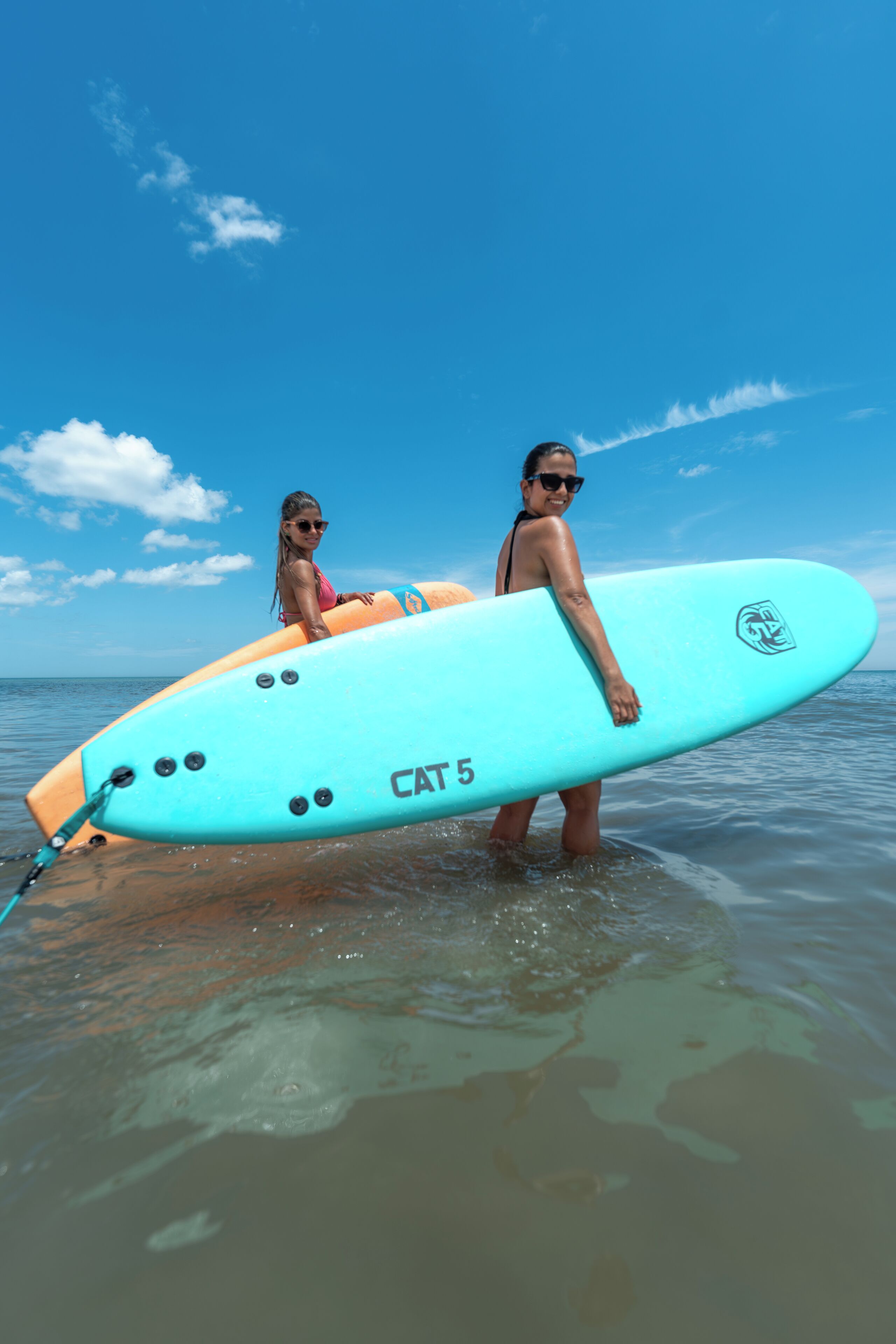 Two people holding a surfboard in the ocean.