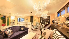 Experience the stylish lobby with a plush sofa, elegant chandelier, and sophisticated decor.