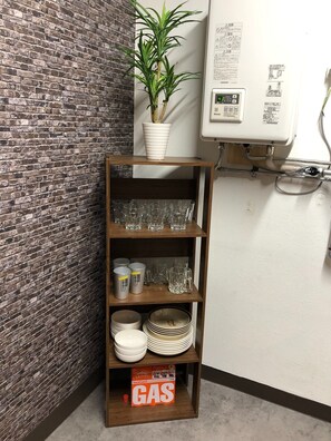 A corner shelf unit with glassware, plates, and a gas canister. - A private hotel reserved for one group in a renova / Otaru Hokkaidō (Otaru)