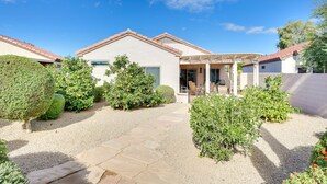 A house with a patio, a garden with various plants, and a clear blue sky. - Hike & Golf! Extended Surprise Stay w/ Pool Access (Surprise)