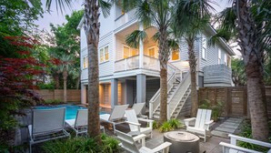 A two-story house with a balcony, a pool, and outdoor seating. - 5BR 4.5 BA Beach House close to beach on IOP with Private Pool! (Isle of Palms)