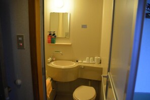 Features a compact bathroom with a sink, toilet, and mirror.