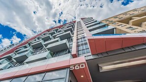 Un edificio moderno con un llamativo letrero '560', grandes ventanales y fachada de vidrio reflectante.