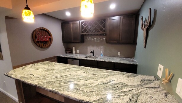 A kitchen with a large granite island, dark wooden cabinets, and pendant lighting. - Westy Escape 2 Living Rooms, 2 Primary Bedrooms, Bar, BBQ, FirePit, Patio (Westminster)