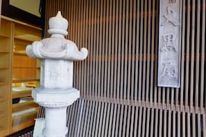 A stone lantern and a vertical wooden panel with carved characters.