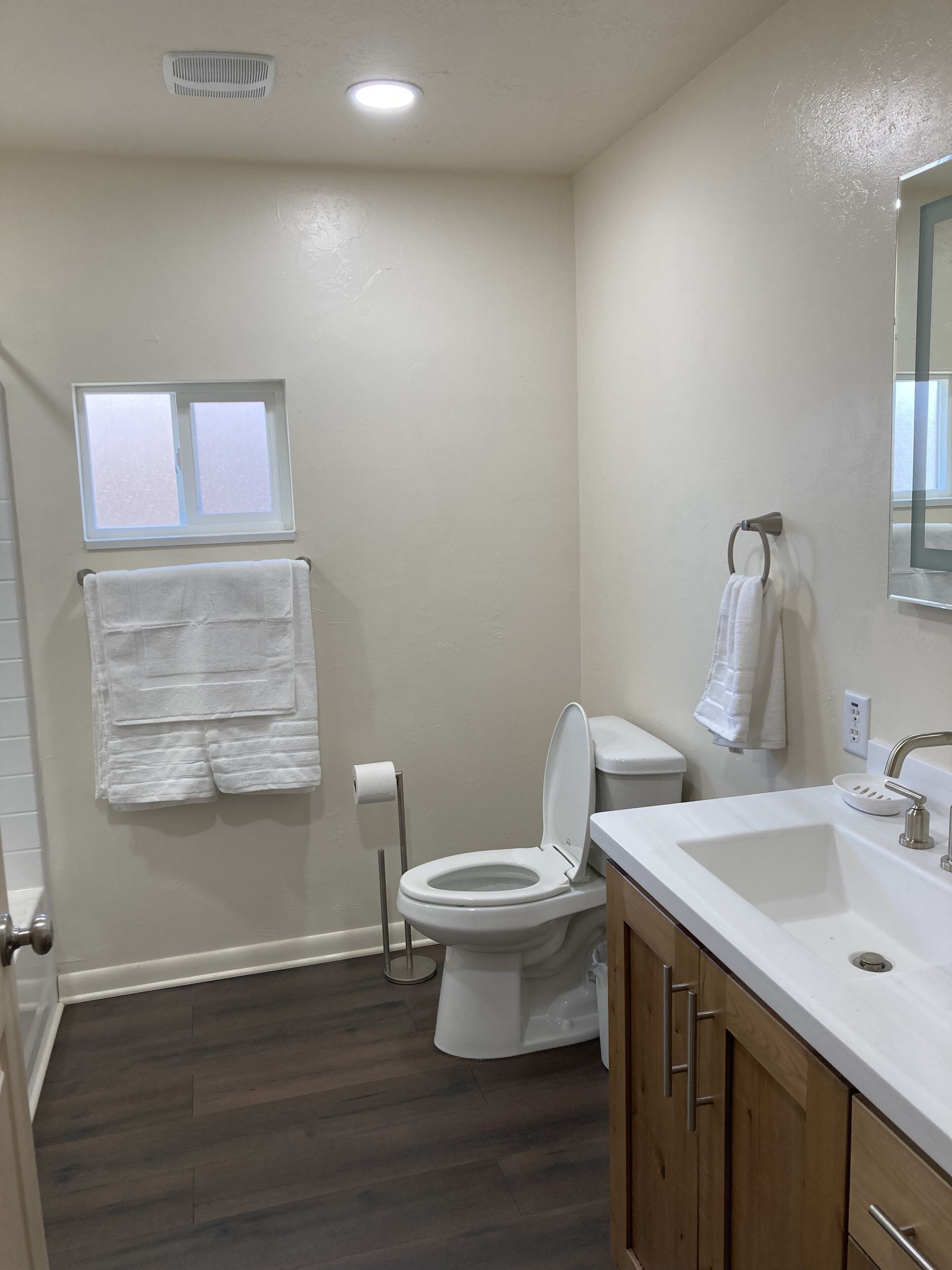 Un baño con inodoro, lavabo y ventana.