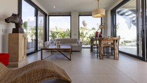 A spacious living area with a sofa, coffee table, and dining table. - Villa Iside - Santa Maria Del Fo... (Santa maria del focallo)