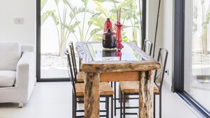 A dining area with a wooden table and chairs, a hanging light fixture, and a view of the outdoors. - Villa Iside - Santa Maria Del Fo... (Santa maria del focallo)