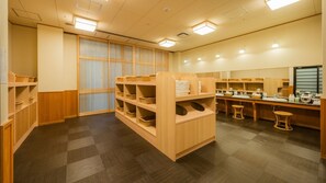 Une pièce propre et bien éclairée, avec des étagères en bois, un grand miroir et un sol à carreaux.
