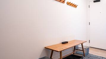 A room with a wooden table, a coat rack, and a door.