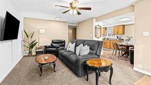 Ein Wohnzimmer mit einer Couch, einem Couchtisch und einem Deckenventilator.
