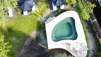 Una piscina al aire libre, sillones reclinables de piscina