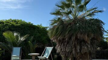 Una piscina al aire libre, sillones reclinables de piscina