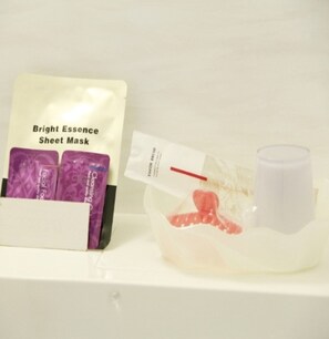 A Bright Essence Sheet Mask package with a face mask and a small container.