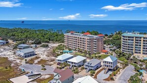 A coastal hotel with multiple buildings, a swimming pool, and a view of the ocean. - 401 Dunes at the end of Fort Morgan Road (Gulf Shores)