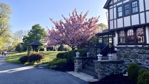 A Tudor-style building with a stone facade, a well-maintained garden, and a clear sky. - Spectacular Historic Mansion w/Pool&Tennis (Goshen)