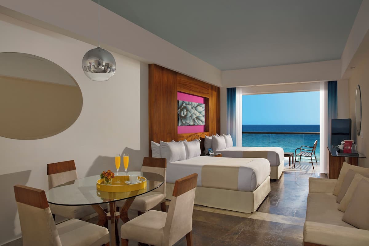 Une chambre d’hôtel avec un balcon, un coin repas et un lit.
