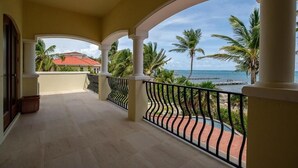 Ein Balkon mit Blick auf das Meer und Palmen.